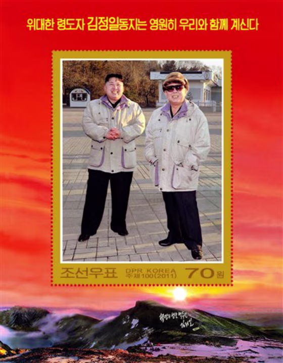 In this undated photo released by the Korean Central News Agency and distributed in Tokyo by the Korea News Service on Friday, a commemorative postage stamp featuring late North Korean leader Kim Jong Il and his son Kim Jong Un is shown. The words on the top read "The great leader comrade Kim Jong Il will always be with us."
